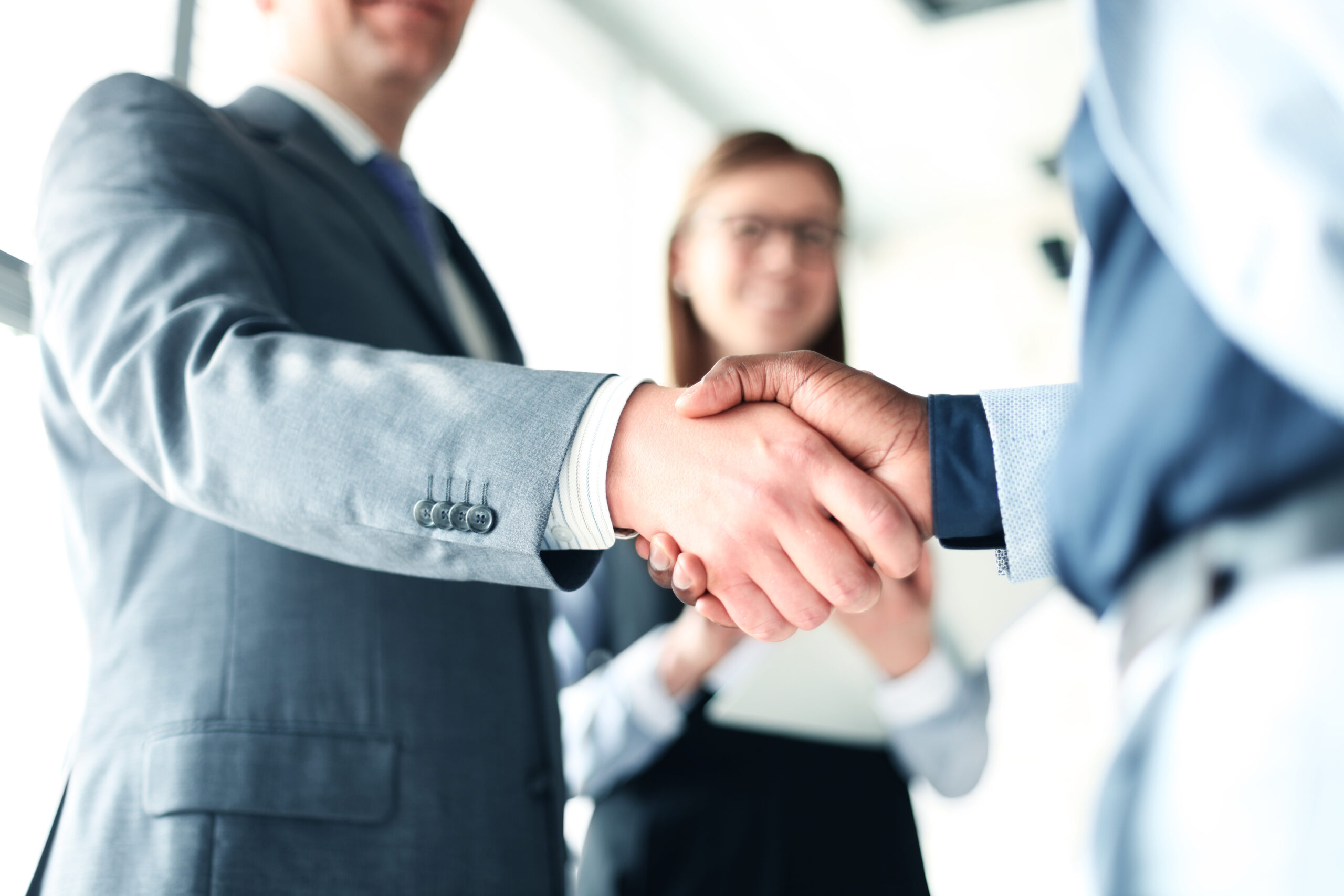 Business professionals shake hands in an office setting